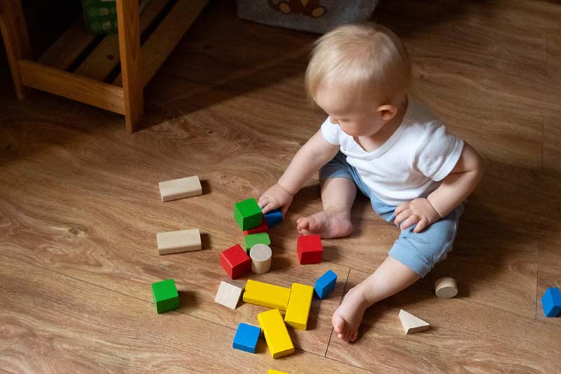 child4 a toddler boy on the floor playing with blocks